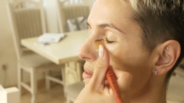 Make-up Specialist kunstenaar maakt een blonde vrouw model mooie zachte make-up vóór een belangrijke gebeurtenis. stap voor stap — Stockvideo