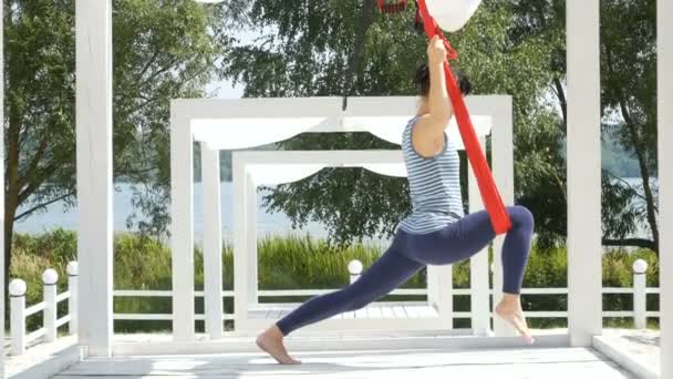 Woman doing aerial fly yoga exercising outdoor — Stock Video