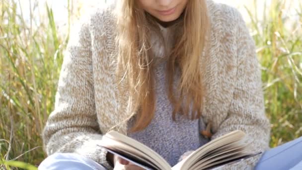 Mujer joven leyendo libro en el parque — Vídeo de stock