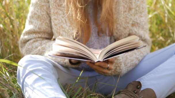 Young woman reading book in park — Stock Video