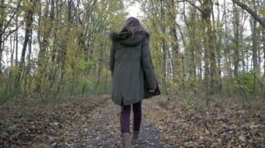 Genç kadın yürüyüş sonbahar ormandaki ağaçlar arasında