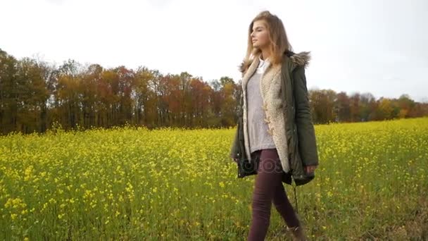 Chica romántica belleza caminando sola a través del campo de violación de trigo amarillo. Mujer joven disfrutando de la naturaleza al aire libre. Soledad con la naturaleza . — Vídeos de Stock