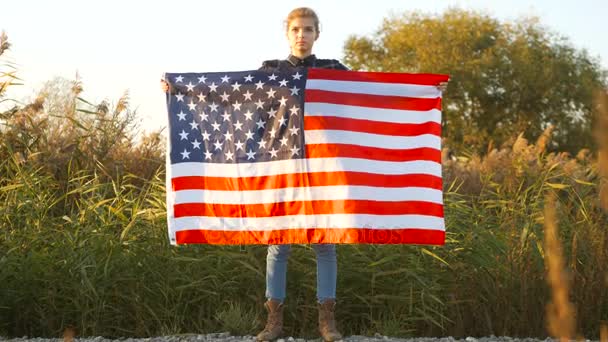 Vlastenecké hrdý, krásná mladá žena s americkým Usa hvězdy a pruhy vlajky. koncept svobody a památník — Stock video