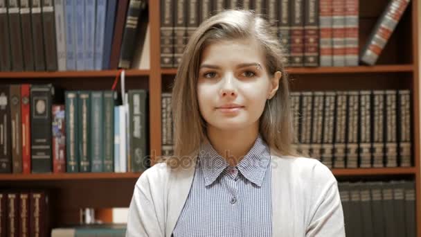 Portret van lachende mooie vrouw in bibliotheek — Stockvideo