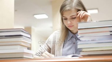 Kız öğrenci okuma ve bütün gün kütüphanede okuyan sonra uykuya dalar