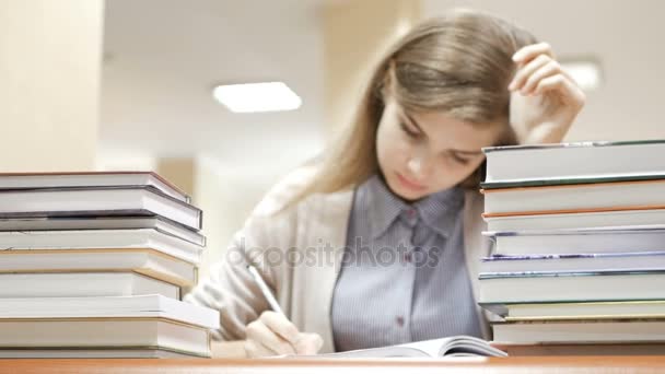 Mujer estudiante se duerme después de haber estado leyendo y estudiando todo el día en la biblioteca — Vídeos de Stock