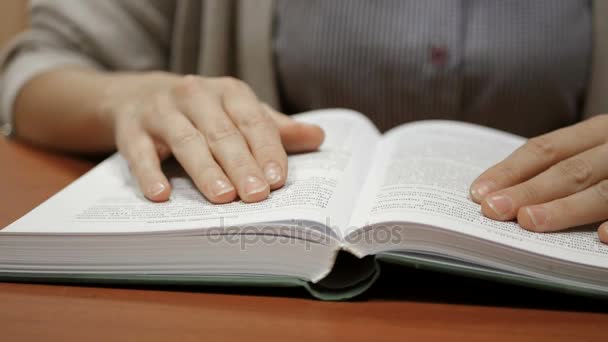 Close-up shot van vrouw hand lezen van een boek binnenshuis — Stockvideo