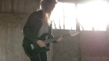 Seksi heyecanlı neşeli genç kadın gitarist müzisyen elektro gitar ile siyah deri ceketli 