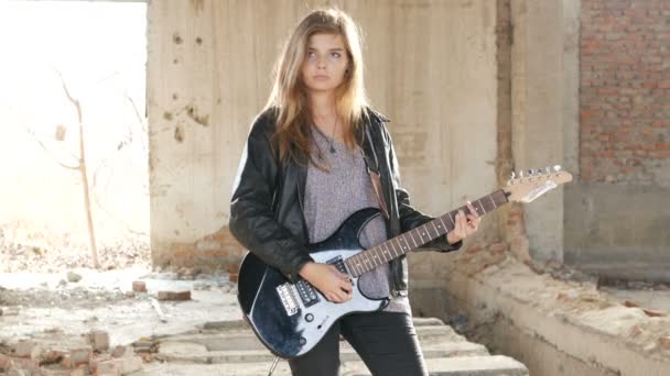 Sexy opgewonden vrolijke jonge vrouw gitarist muzikant in zwart lederen vest met elektrische gitaar — Stockvideo