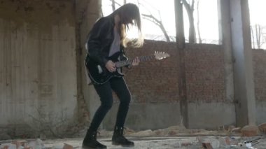 Seksi heyecanlı neşeli genç kadın gitarist müzisyen elektro gitar ile siyah deri ceketli 