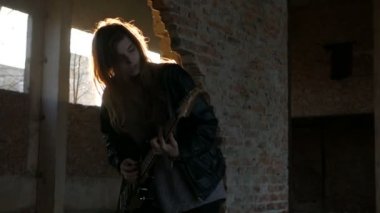 Seksi heyecanlı neşeli genç kadın gitarist müzisyen elektro gitar ile siyah deri ceketli 