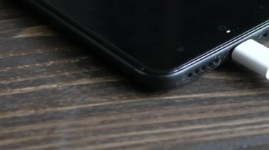 Ahşap masanın üzerinde şarj mobil akıllı telefonlar