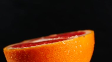 Yarım greyfurt, siyah bir arka plan üzerinde döndürme