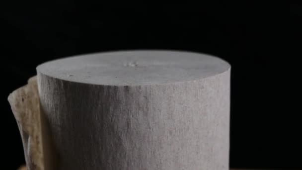 Rollo de papel higiénico giratorio sobre fondo negro — Vídeos de Stock