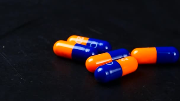 Drug prescription for treatment medication. Pharmaceutical medicament, cure in container for health. Pharmacy theme, Heap of orange blue round capsule pills with medicine antibiotic in packages — Stock Video
