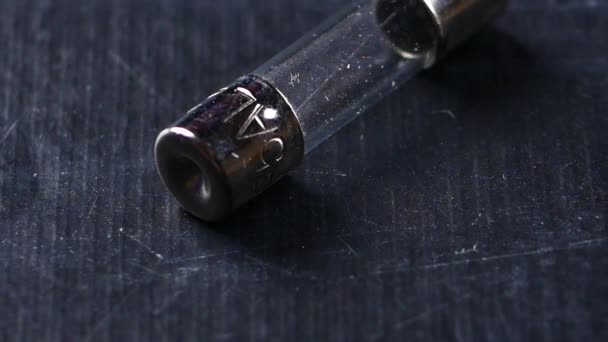 Fusível elétrico em forma de cápsula de vidro, sobre fundo preto. Macro shot — Vídeo de Stock