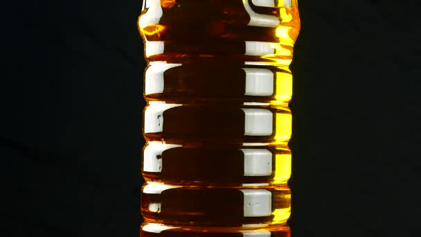 Oil in plastic bottle on black background — Stock Video