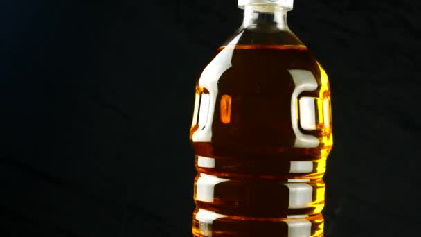 Oil in plastic bottle on black background — Stock Video