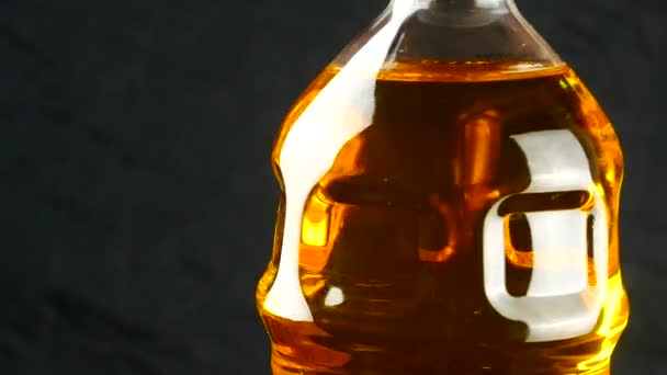 Oil in plastic bottle on black background — Stock Video