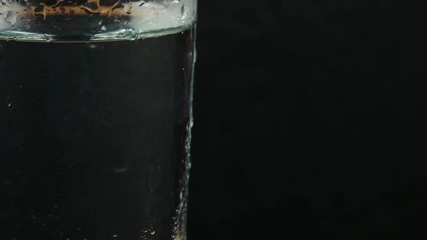 Glass with water on a black background — Stock Video