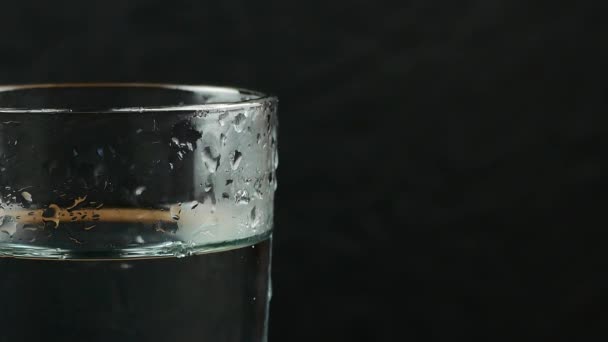 Verre avec de l'eau sur fond noir 
