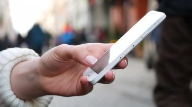 Yakın çekim Shot kadının ellerini kullanarak cep telefonu içinde meşgul halka açık bir yerde