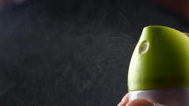 Toz boya spreyi elinde siyah arka plan, gaz ile deodorant balon üzerinde yakın çekim