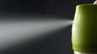 Toz boya spreyi elinde siyah arka plan, gaz ile deodorant balon üzerinde yakın çekim