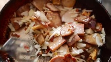 Aşçı pan et kızartma. Adam yanan tavada et kızartma. Bir tava üzerinde ateş. Yakın çekim. Et ateş üzerinde bir tavada kavurma.