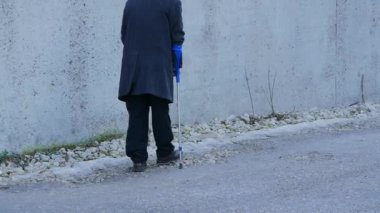 yaşlı özürlü insanlar arka plan. koltuk değneği ile kamuoyunda eski adam girer.