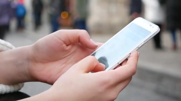 Крупный план съемки женских рук с помощью мобильного телефона в оживленном общественном месте — стоковое видео