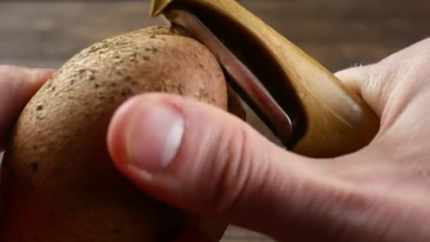 Handen schillen van aardappelen in de keuken — Stockvideo