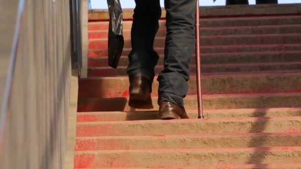 Старий чоловік піднімається по сходах зі своєю палицею — стокове відео