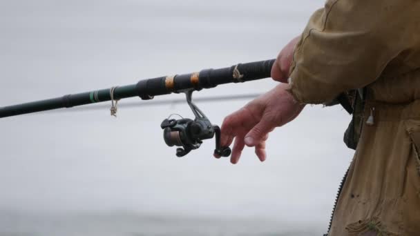 Gros plan d'une main de pêcheur avec une canne à pêche — Video