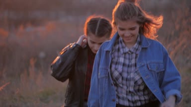 iki genç kadın en iyi arkadaş, gün batımını arka plan üzerinde kameraya geç. yaz tatil, bayram, tatil, seyahat ve insanlar kavramı