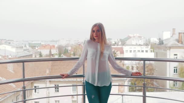 Портрет молодой красивой блондинки в белой рубашке и джинсах — стоковое видео