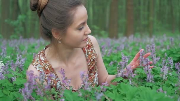 Jonge mooie vrouw geniet van bos bloemen — Stockvideo