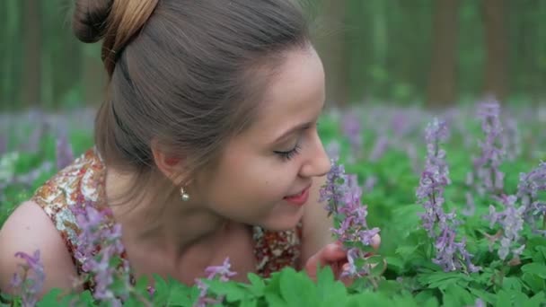 Joven hermosa mujer disfruta de flores del bosque — Vídeos de Stock