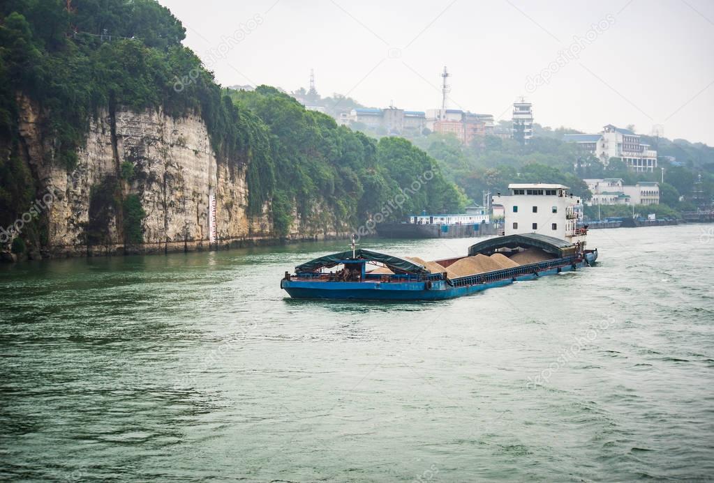 Cargo ship cruising on Yangtze river in rainy day
