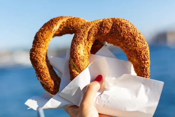 Bagels with sesame in hand — Stock Photo, Image