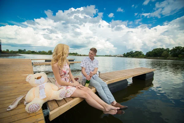 Adam şampanya bir iskele üzerinde oturan bir kadın ile bir tarihte açar