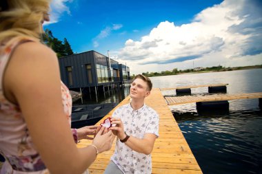 dostum bir iskelede diz üzerinde duran bir evlenme teklifi yapar