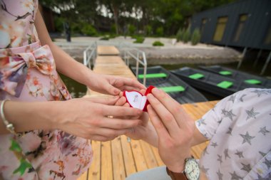 dostum bir iskelede diz üzerinde duran bir evlenme teklifi yapar