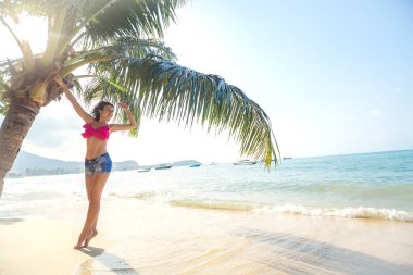 Palmiye ağacı ile sahilde poz güzel kız