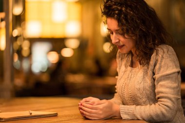 Kız fincan sıcak kahve ve hatmi ile kafede not yazma