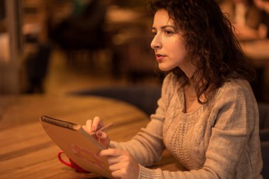 bir fincan sıcak kahve ile bir kafede kız çizer