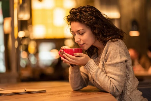 Kız fincan sıcak kahve ve hatmi ile kafede not yazma