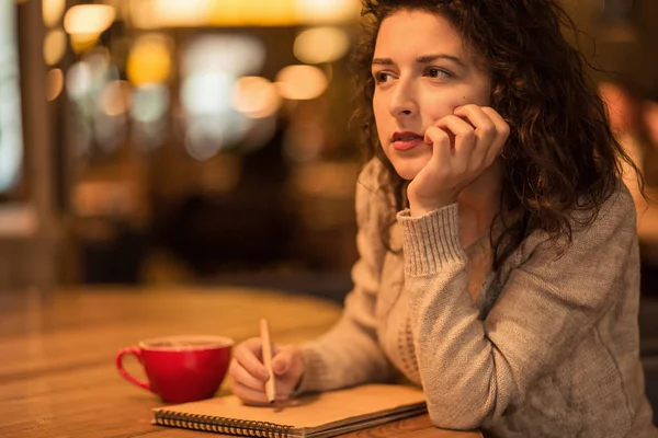 Meisje schrijven nota's in café met een kopje warme koffie en marshmallow — Stockfoto