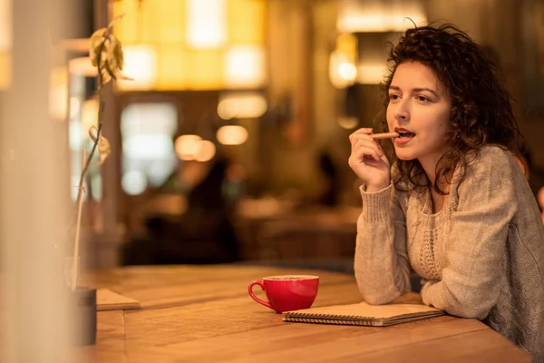 Kız fincan sıcak kahve ve hatmi ile kafede not yazma