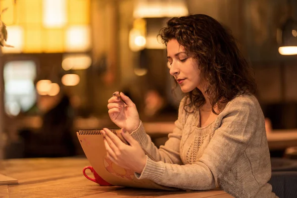 Meisje schrijven nota's in café met een kopje warme koffie en marshmallow — Stockfoto